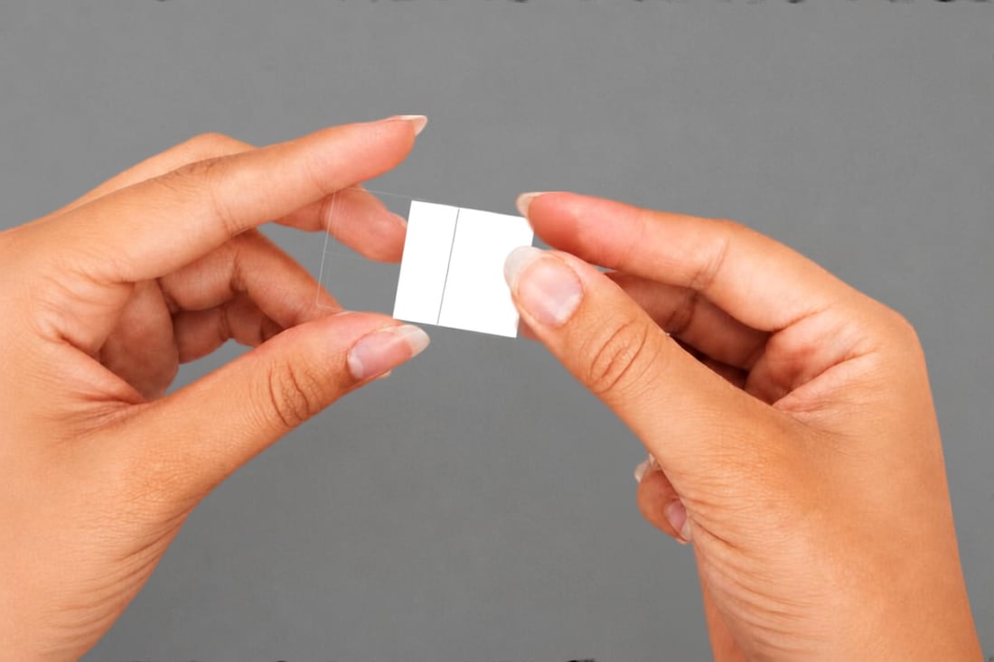 Deux mains glissent un visuel imprimé dans son étui transparent